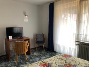 a bedroom with a bed and a television and a chair at Ohana Bed and Breakfast in Zorge