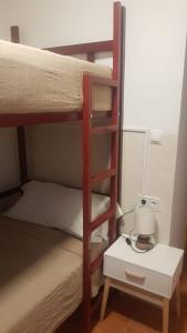 ein Schlafzimmer mit 2 Etagenbetten und einem Nachttisch mit einer Lampe in der Unterkunft Joy Beach B&B in Torremolinos