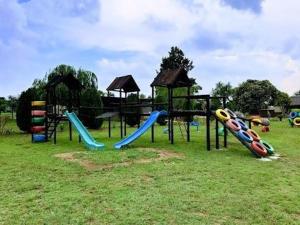 un parque infantil con toboganes y equipo de juegos en un campo en Vaal Marina Resort, en Vaal Marina