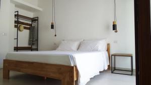 - une chambre dotée d'un grand lit avec des draps et des oreillers blancs dans l'établissement Villa Mameli b&b, à Rena Majore