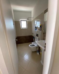 a bathroom with a toilet and a sink at Gerard apartments in Sarandë +23 photos