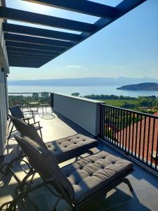 a balcony with two chairs and a bench on it at La Vista Luxury Villa in Ohrid