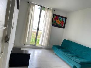 sala de estar con sofá azul y ventana en Confortable Apartamento en Ibagué con piscina solo Fines de semana solo para FAMILIAS, en Ibagué