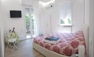 a white bedroom with a pink bed and a table at Borgo and Bike in Finale Ligure