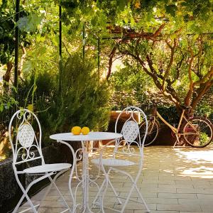 stół z dwoma krzesłami i stół z pomarańczami w obiekcie Borgo and Bike w mieście Finale Ligure