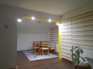 uma sala de jantar com uma mesa e uma luz amarela em Pejovic em Višegrad