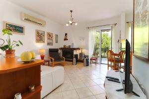 a living room with a couch and a tv in it at Zoumberi Cute and Cozy in Nea Makri