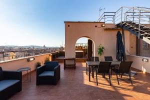 taras ze stołem i krzesłami na budynku w obiekcie VIVILO ROMA TREVI - LUXURY EXPERIENCE - PRIVATE JACUZZI on TERRACE - INSANE VIEW w Rzymie