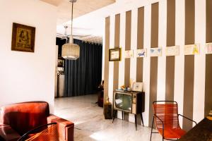 a living room with a tv and chairs at Be Playa Hotel Boutique & Rooftop Bar - Adults Only in Playa del Carmen