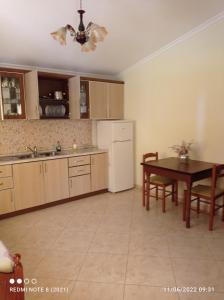 a kitchen with a table and a dining room at Guesthouse Fatos Biti in Divjakë