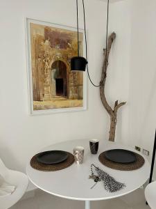 uma mesa branca com duas placas pretas em Artemide Luxury Home em Siracusa