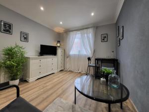 a living room with a glass table and a television at Lovely Apartment close to the Town Centre & Train Station in Northampton