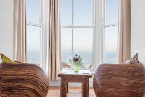 a living room with two chairs and a table in front of a window at organic panda in St Ives