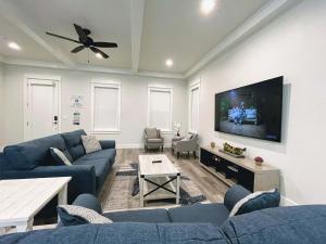 a living room with blue couches and a flat screen tv at Seabreeze - 30A by Southern Vacation Rentals in Blue Mountain Beach