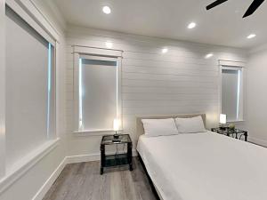 Un dormitorio con una cama grande y dos ventanas. en Seabreeze 30A, en Blue Mountain Beach 26 fotos más
