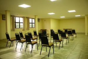 an empty room with chairs and tables and windows at Executivo Park Hotel in São Borja