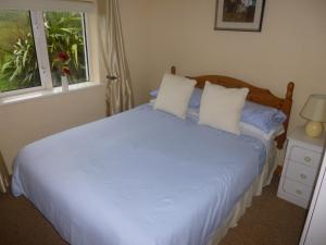 A bed or beds in a room at The Ocean Wave Bed & Breakfast