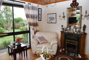 a living room with a chair and a fireplace at The Ocean Wave Bed & Breakfast in Cleggan +9 photos