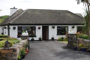 a house with two swans on the front of it at The Ocean Wave Bed & Breakfast in Cleggan