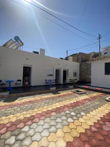 a large white building with a colorful floor at Gerard apartments in Sarandë