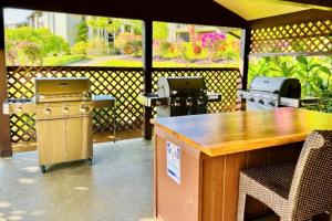 an outdoor patio with a grill and two bbqs at Hanalei Bay Resort 7301 in Princeville