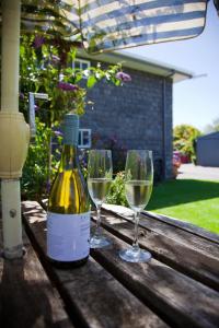 two glasses of white wine sitting on a wooden table at Central Motel Port Fairy in Port Fairy