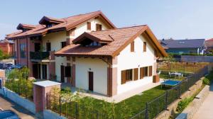 una casa bianca con tetto marrone di Villa Green a Pianezza