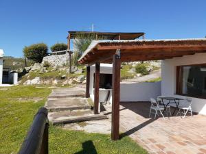 dom z patio, stołem i krzesłami w obiekcie Cabañas Loma de El Pelao w mieście Tafí del Valle