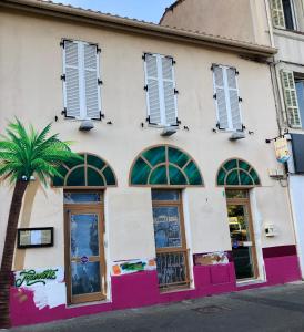 un bâtiment avec un palmier en face dans l'établissement Les Chambres de Jeannette, à Marseille