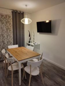 a dining room with a wooden table and white chairs at Apartamenty Szczawnica A2 in Szczawnica