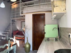a kitchen with a sink and a spiral staircase at Loft Kapodistrias in Corfu
