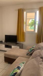 a room with two beds and a television and a window at villa des aigles in Anse-Bertrand
