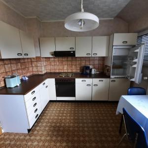 a kitchen with white cabinets and a black appliance at Lütke-Dörhoff in Ennigerloh +3 photos