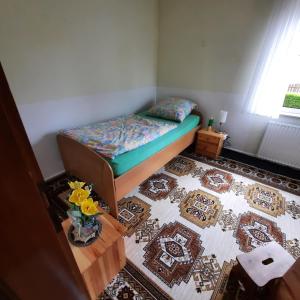 Dormitorio pequeño con cama y alfombra en Lütke-Dörhoff, en Ennigerloh
