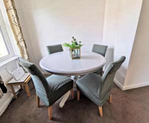 een witte tafel met stoelen en een vaas erop bij 2 bed apt w/ private parking close to town centre in Huntingdon