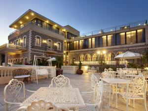a patio with tables and chairs in front of a building at Europa 1917 - Mehadrin Kosher suitable for Ultra-Orthodox guests in Tiberias