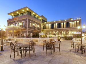 a restaurant with tables and chairs in front of a building at Europa 1917 - Mehadrin Kosher suitable for Ultra-Orthodox guests in Tiberias