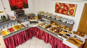 un bancone di panetteria con molti tipi di cibo diversi di Hotel Regina a Lignano Sabbiadoro