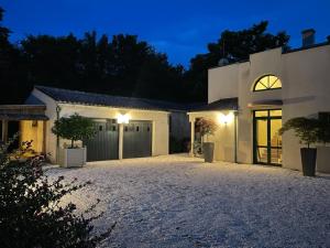 a house with a driveway at night at L'escale au Port Miniature de Saint Savinien in Le Mung