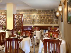 a restaurant with tables and chairs and a brick wall at Europa 1917 in Tiberias