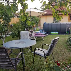 einen Tisch, Stühle und einen Regenschirm im Hof in der Unterkunft Apartmani Filipi in Vrnjačka Banja