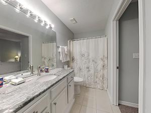 a bathroom with a sink and a toilet and a mirror at Grand Caribbean Perdido Key #306 West in Perdido Key