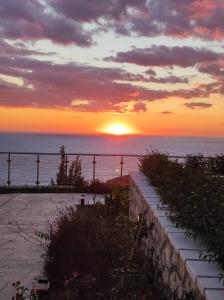 a sunset over the ocean with the sun setting at MELIKIRON LUXURY APARTMENTS in Ayios Nikitas