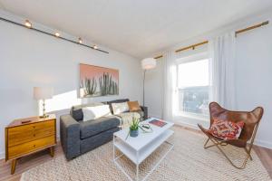 ein Wohnzimmer mit Sofa und Tisch in der Unterkunft Music Row Retreat with Pool and Free Parking, Walk to Bars! in Nashville