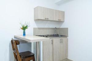 a kitchen with a counter and a sink and a chair at Hotel Granada Loft in Cali