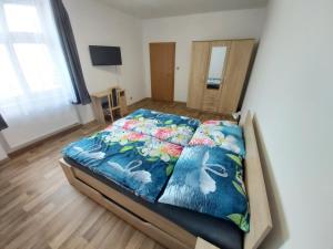 - une chambre avec un lit doté d'un couvre-lit coloré dans l'établissement Apartmány Na Valše, à Sušice
