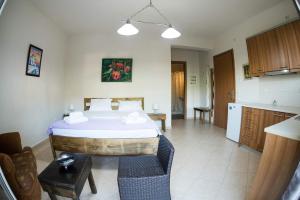 a bedroom with a large bed and a kitchen at Anamniseis in Agreliá