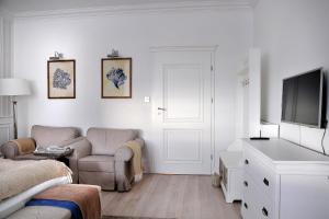 un soggiorno bianco con divano e TV di Villa Celine a Mielno