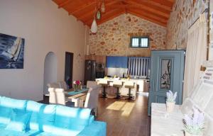 a living room with a blue couch and a kitchen at Villa Tramonto Keri in Keri