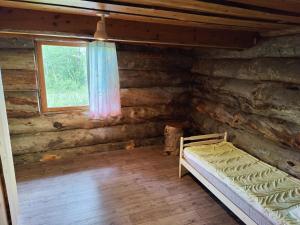 una camera con un letto in una baita di tronchi di Villa Suopursu a Karesuvanto